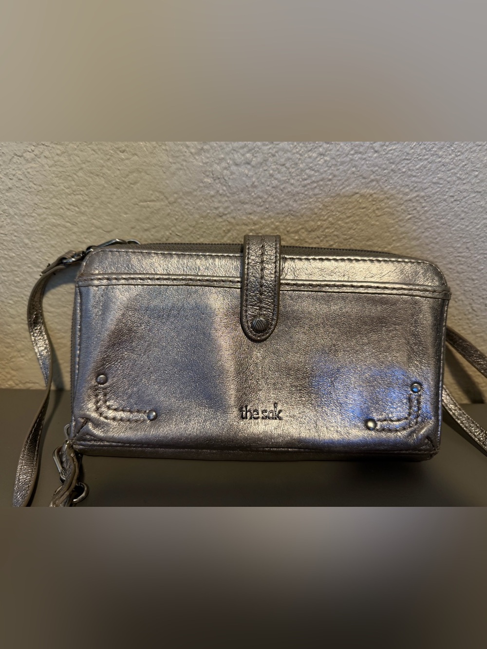 The Sak Silver Metallic Leather Crossbody Wristlet with shoulder strap